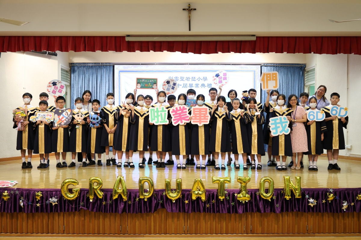 A group of children wearing masks and holding signsDescription automatically generated
